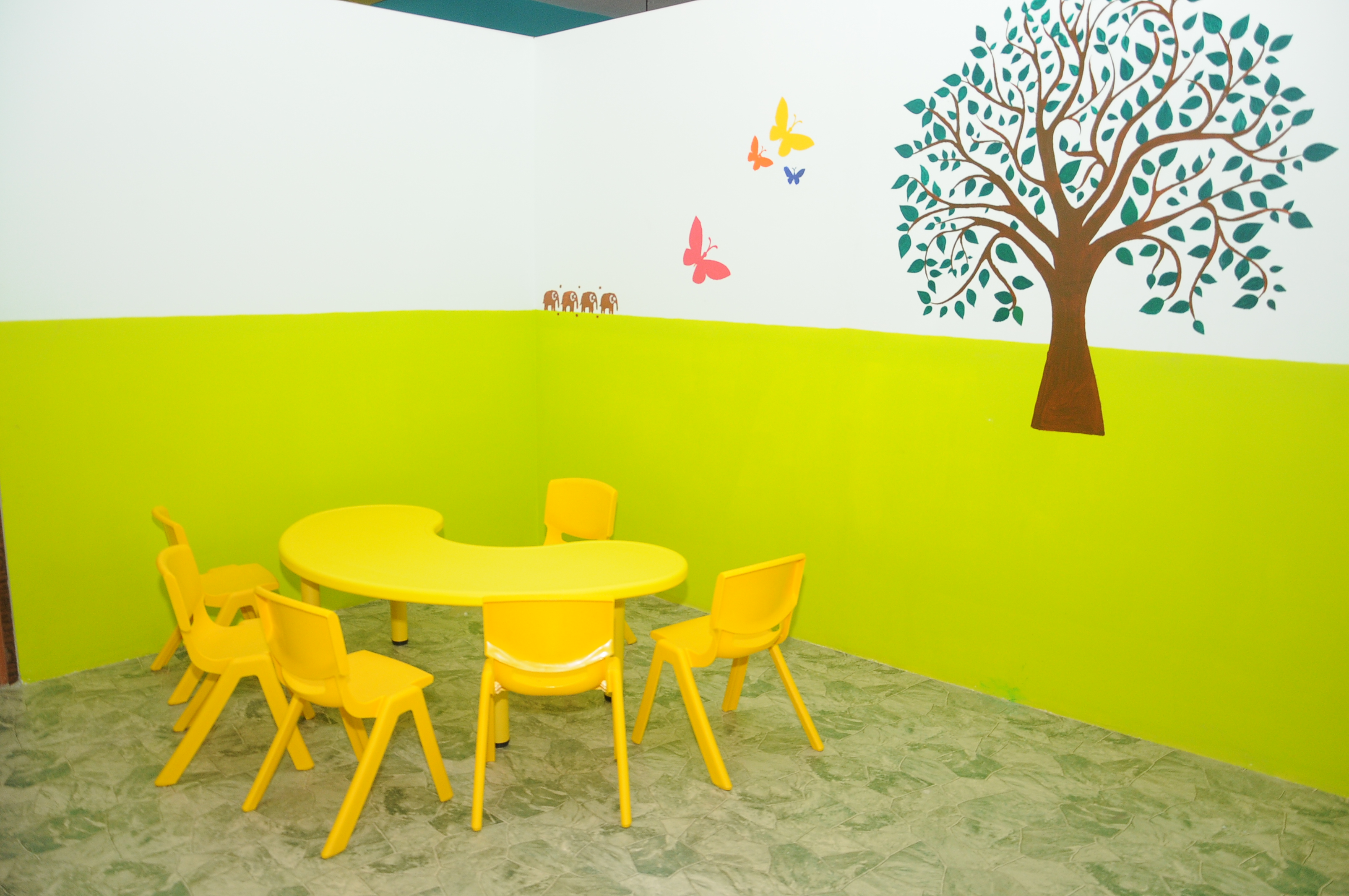 Colourful classroom with small tables and chairs at Kids Mansion