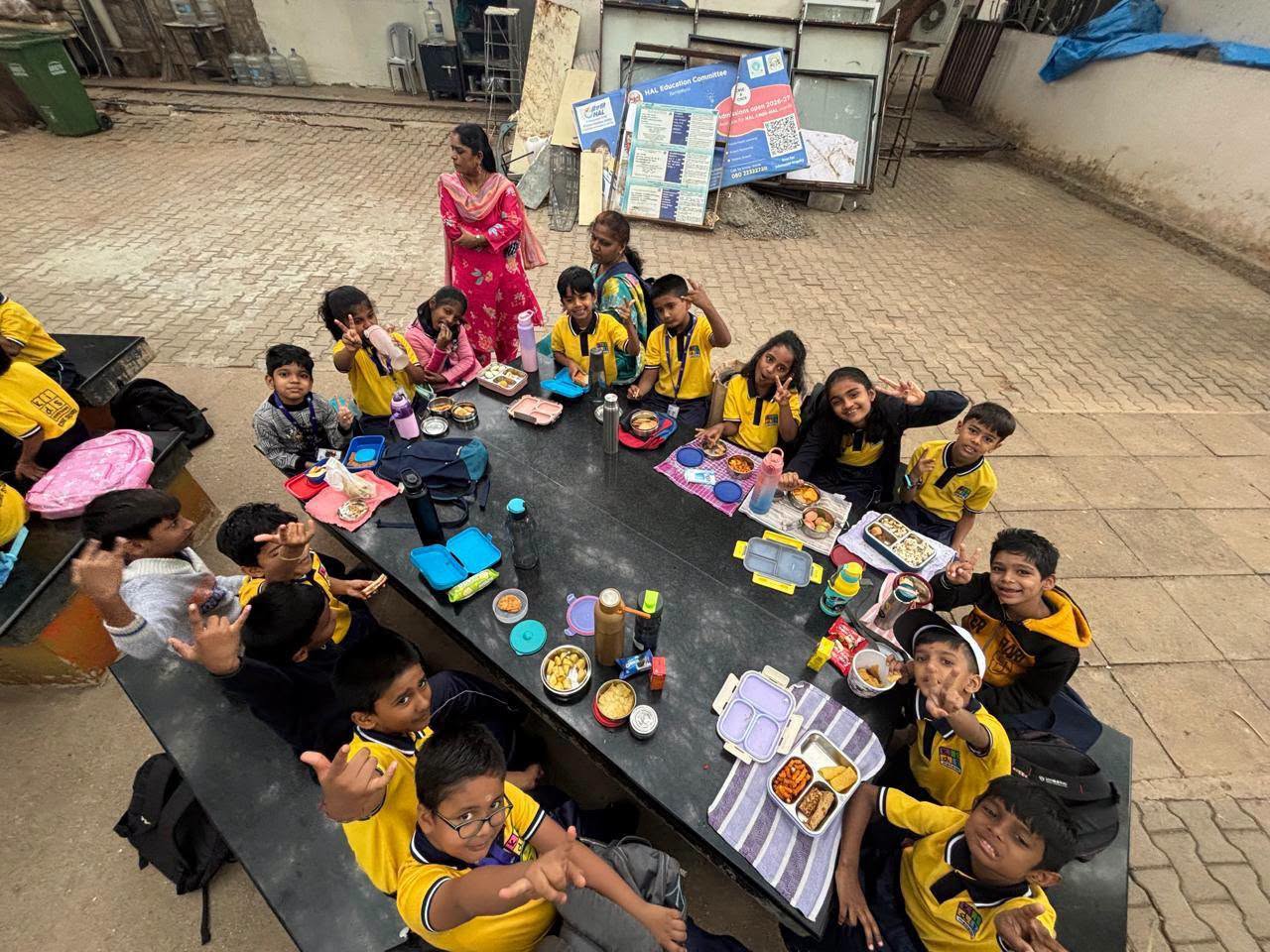 School children and teachers sharing lunch on a trip