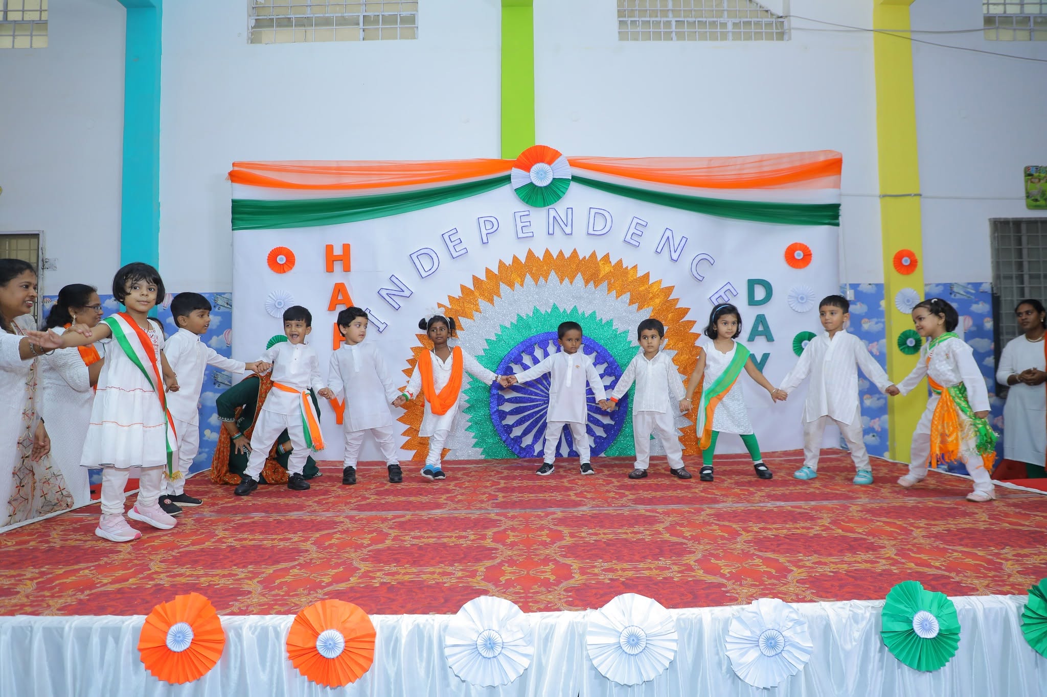 Children performing together on a decorated school stage